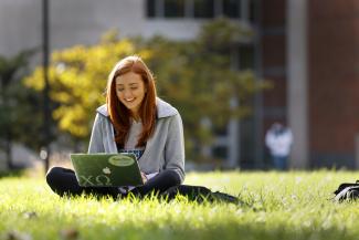 A student works in the grass.
